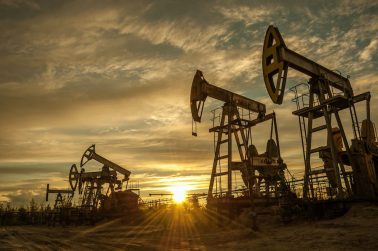 Oil pump jacks at sunset sky background