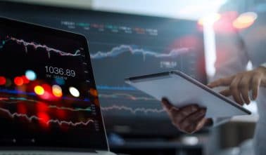 Businessman using tablet and laptop for analyzing data stock market in monitoring room background, forex trading graph, stock exchange trading online, financial investment concept. All on laptop screen are design up.