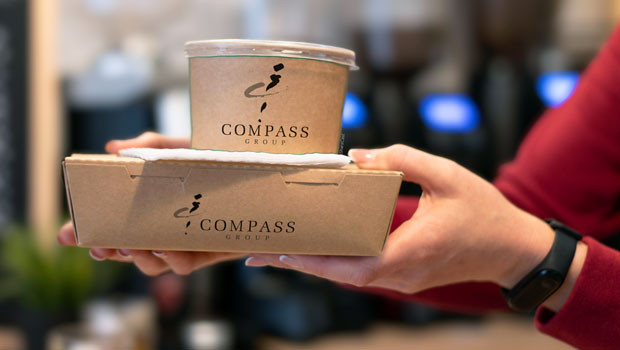 Compass Group take away food containers, held by employee